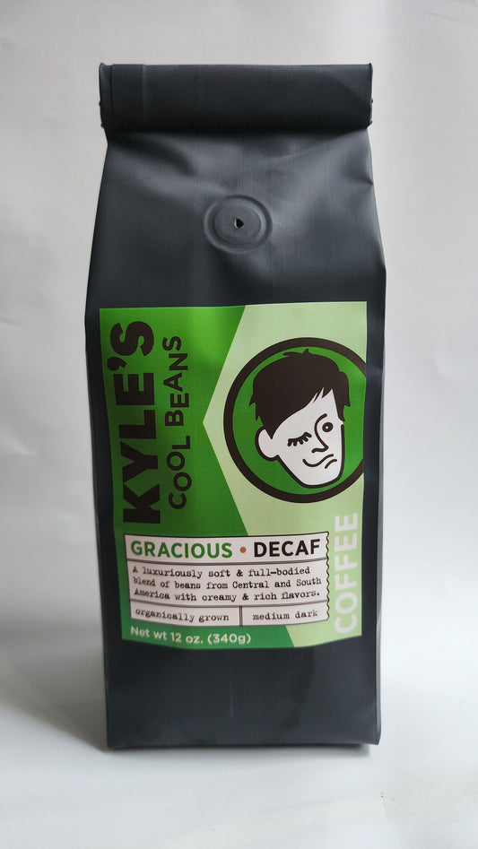 Kyle’s Cool Beans Gracious Decaf, Black bag with a green label, A luxuriously soft & full-bodied blend of beans from Central and South America with creamy & rich flavors. Organically grown. Medium dark.