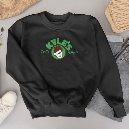 Black sweatshirt with 'Kyle's Cool Beans' logo on a light gray surface with casual items.