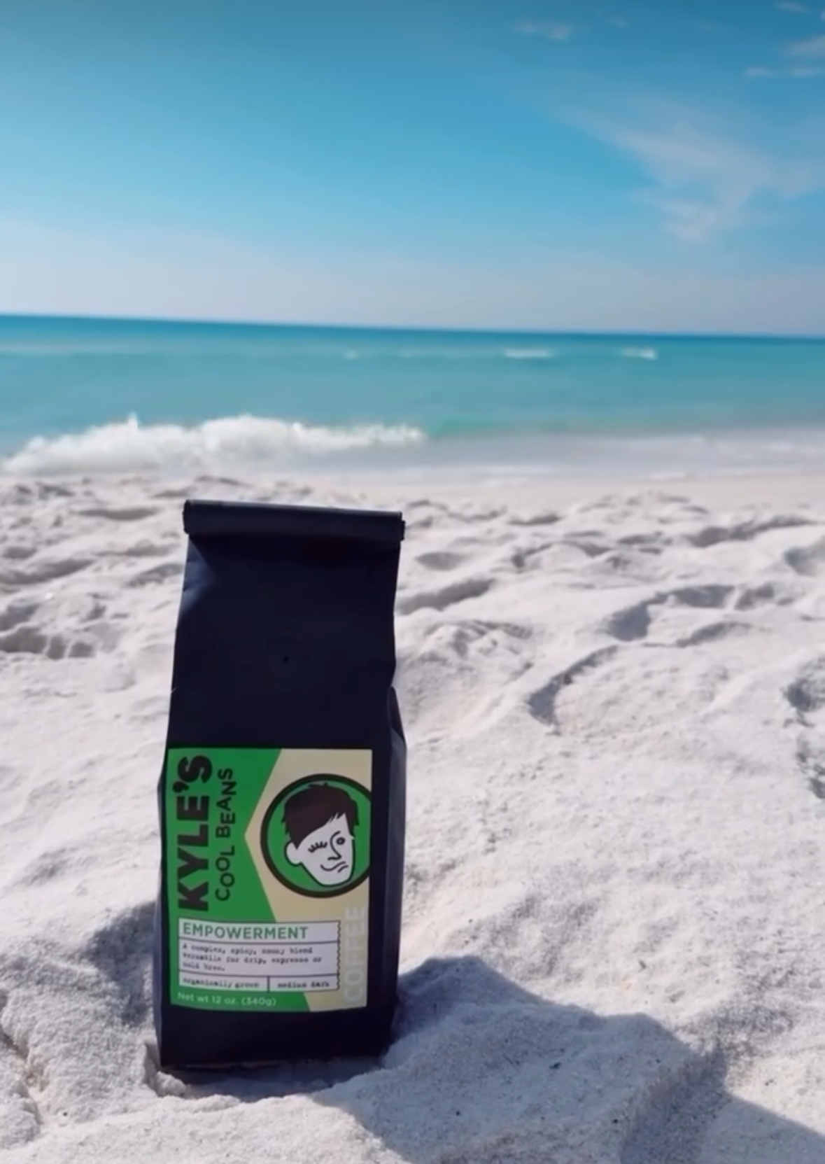 Coffee bag with a brand logo on a sandy beach with ocean view